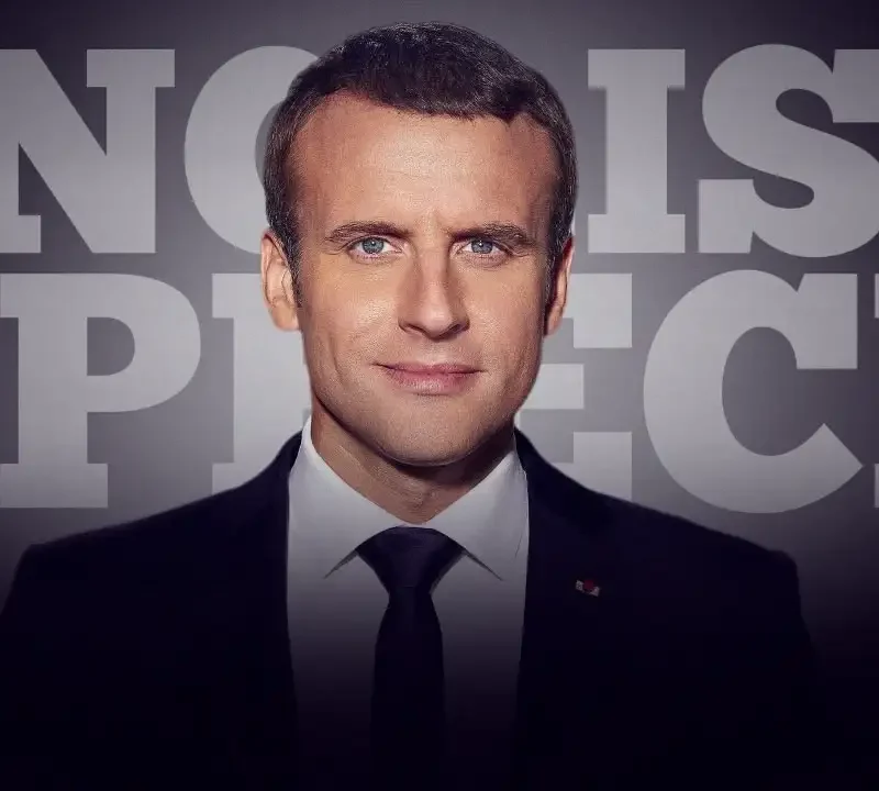 A man in a suit and tie stands in front of large text that reads "ENGLISH SPEECH."