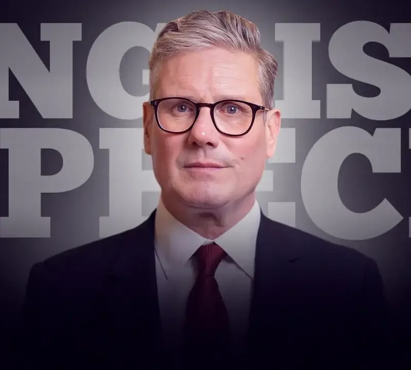 Man in a suit and tie speaking in front of a background with the words "ENGLISH SPEECH."